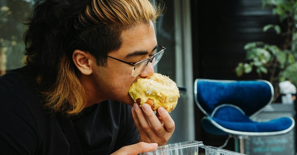persona che mangia una ciambella